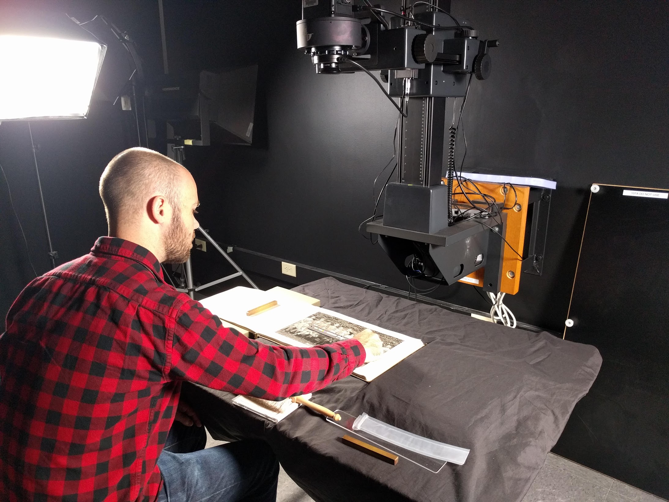 A library staff member is digitizing a book