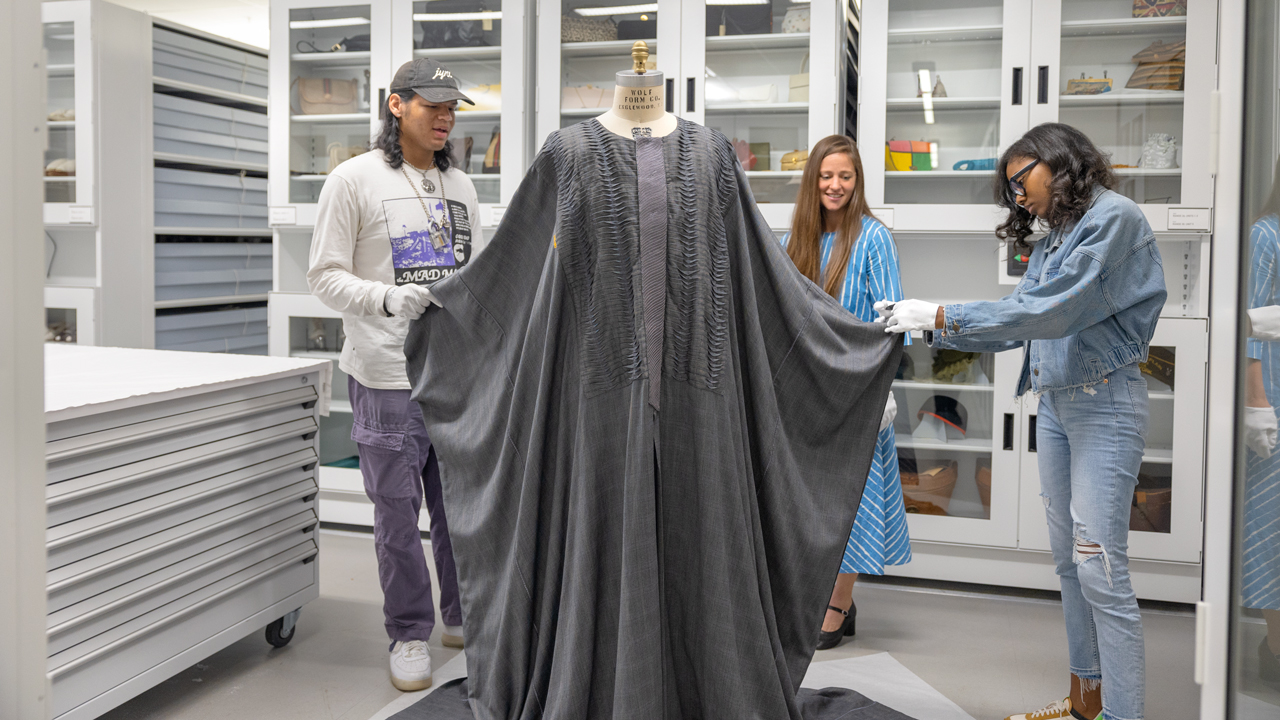 From L - R: Nik Martin '25, Denise Green (associate professor of human centered design in the College of Human Ecology), and Green's advisee Dyese Matthews (doctoral candidate in garment design) admire the caftan owned by Andre Leon Talley and designed by Patience Torlowei in the Cornell Textile Collections. This caftan was designed by Nigerian designer Patience Torlowei and worn/owned by Andre Leon Talley. It was acquired by the Cornell Textile Collections, with assistance from the University's Rare and Manuscript Collections, in 2023.