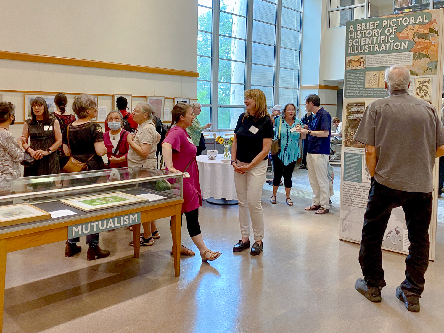An image of people at an exhibit reception at the Mann Library Gallery